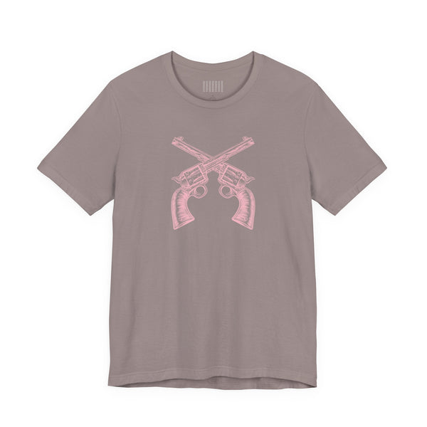 Pink vintage crossed pistols graphic on faded pink outlaw t shirt made from soft cotton with unisex fit
