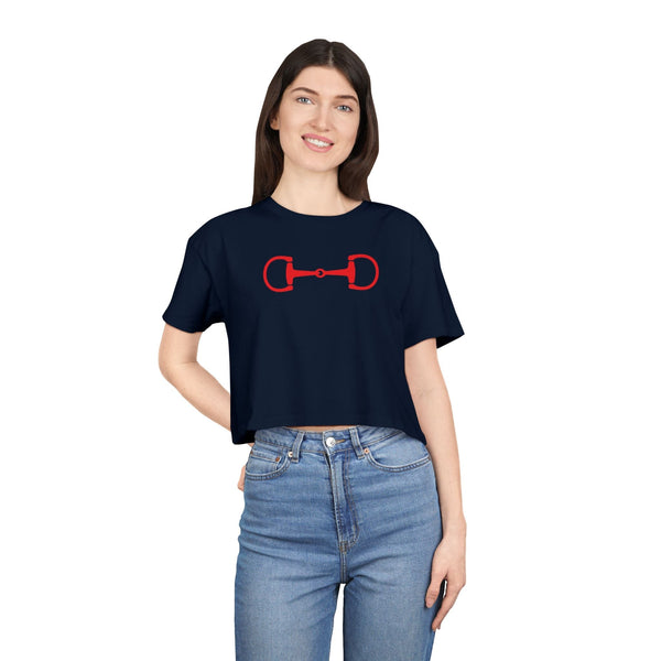 Woman wearing navy blue cropped tee with red horse bit style and blue jeans