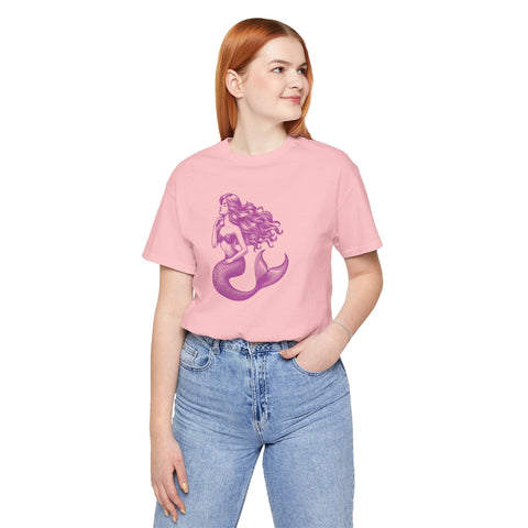 Woman wearing a magenta mermaid siren graphic tee with high-waisted blue jeans