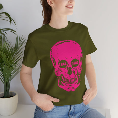 Festival-style olive green t-shirt with jumbo pink skull graphic and "FREE MIND" text in eye sockets, worn by smiling woman.