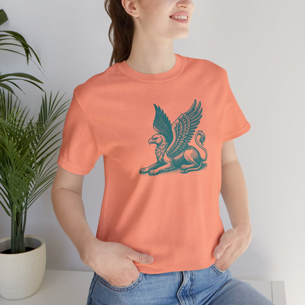 woman wearing peach gryphon t shirt with mythical winged beast graphic sitting with hands in pockets