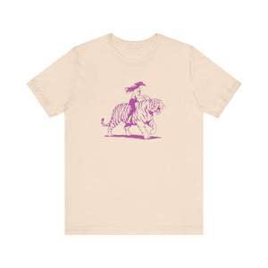 Beige unisex tee with neon magenta graphic of a cowgirl riding a tiger, retro humorous design
