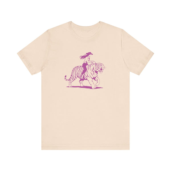 Beige unisex tee with neon magenta graphic of a cowgirl riding a tiger, retro humorous design