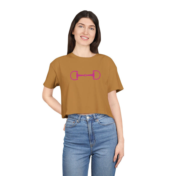 Cropped brown tee with pink horsebit graphic, modern equestrian style, worn with high-waisted jeans