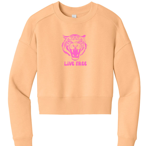 Women's cropped peach sweatshirt with pink roaring tiger graphic and "Live Free" slogan, crew neck, long sleeves, relaxed fit.