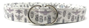 White D-ring belt with lavender beetle pattern on white background by Oliver Green