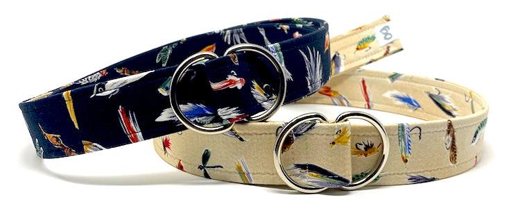 Fly fishing d-ring belts with printed lure designs in navy and beige colors for outdoor enthusiasts